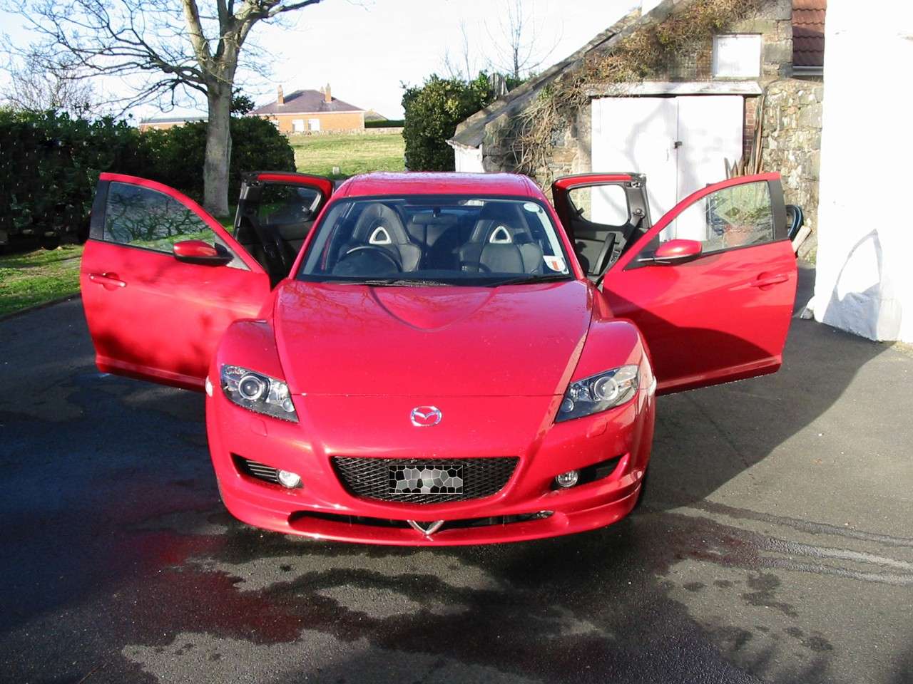 Red Mazda RX-8 viewed from the front with all four doors open