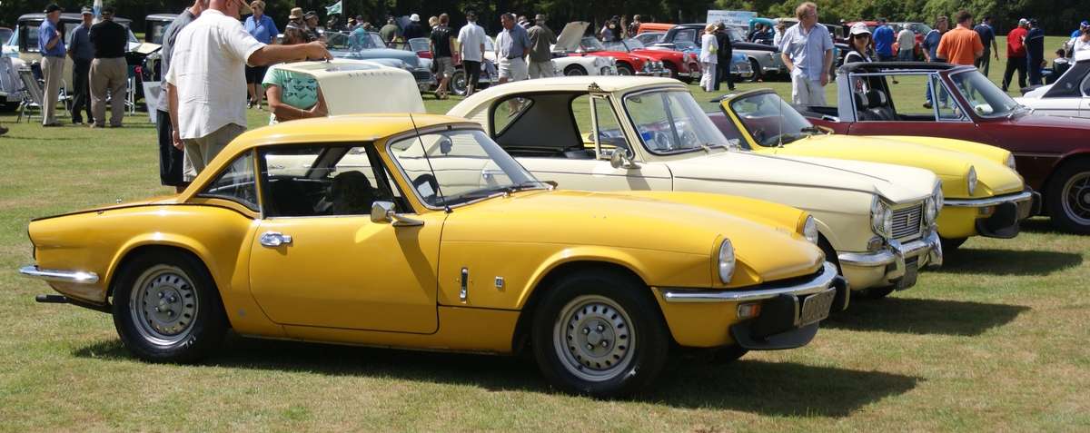 Yellow 1976 Triumph Spitfire 1500 with its soft top raised
