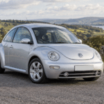 Reflex silver Volkswagen New Beetle 1.8T in the British countryside — illustrative artwork
