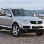 Silver Volkswagen Touareg Mk1 (7L) on a British country road — illustrative artwork